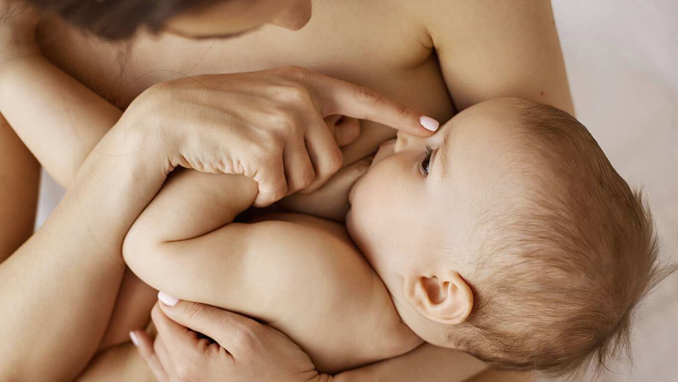 A mother breastfeeding her infant, representing the timeless act of nourishing a child that connects ancient wet-nursing to modern human milk banking.