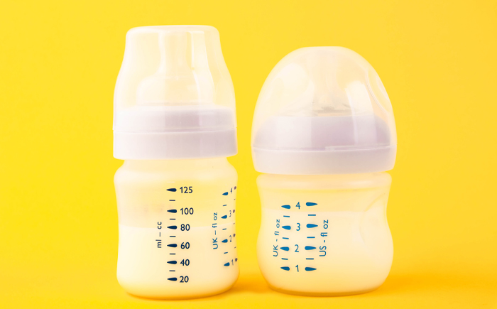 Two bottles of fortified breast milk, representing the standard vs. targeted fortification approaches compared in the cost-benefit analysis