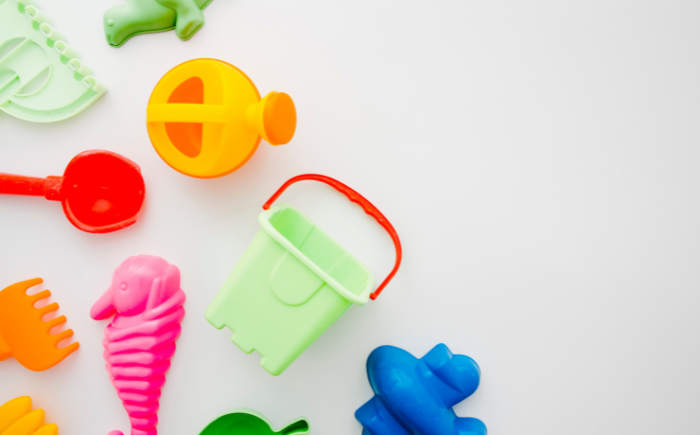 A small sand pail and shovel, symbolizing safe summer activity planning for premature babies in the heat.