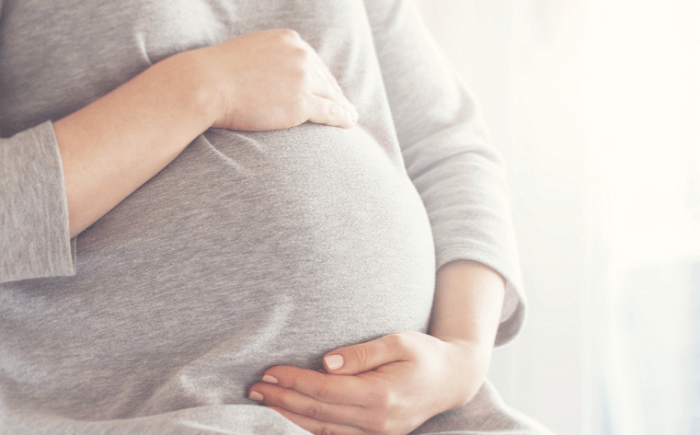 Concerned pregnant woman holding her stomach